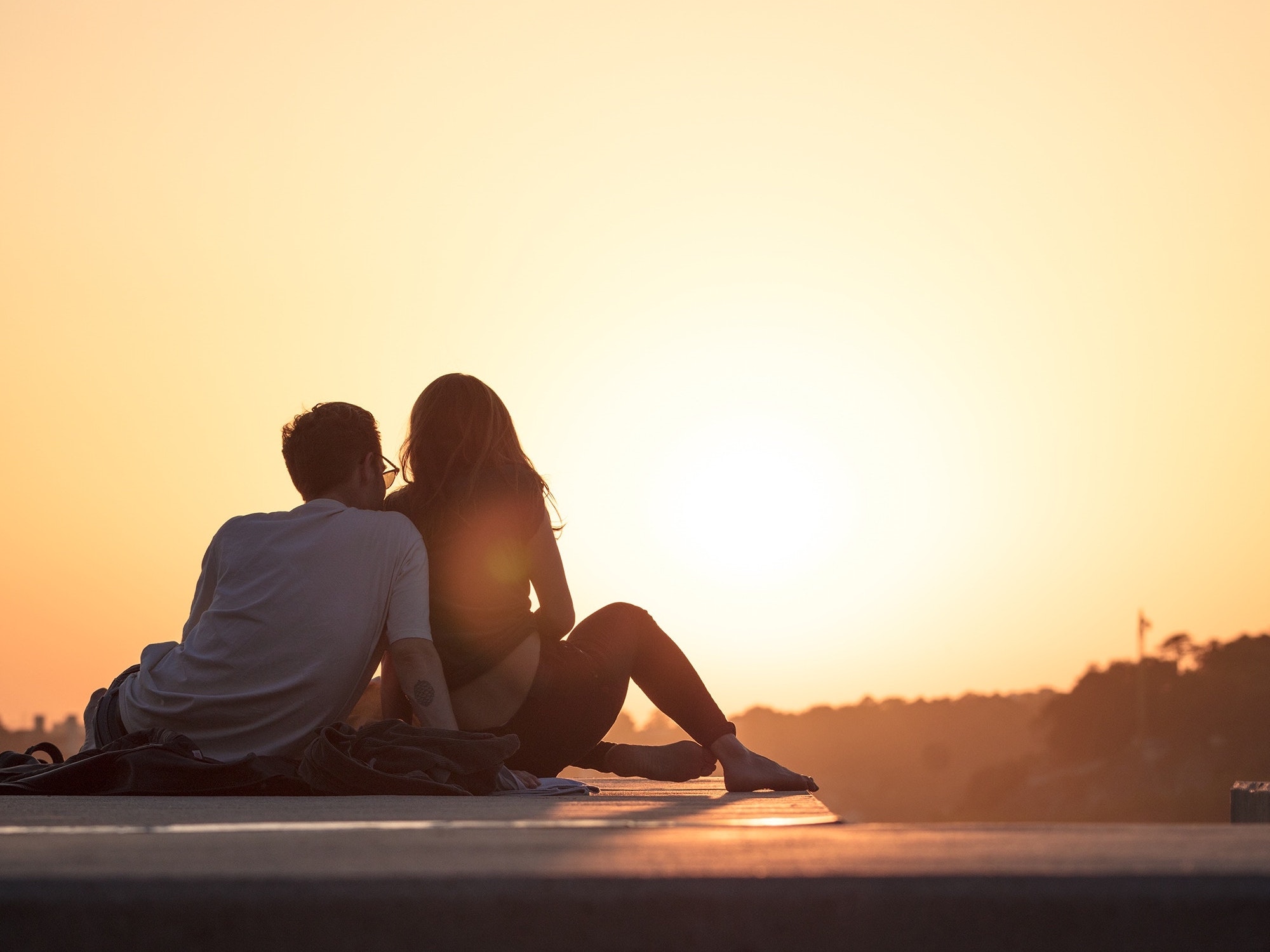 Couple sitting down together to a sunset